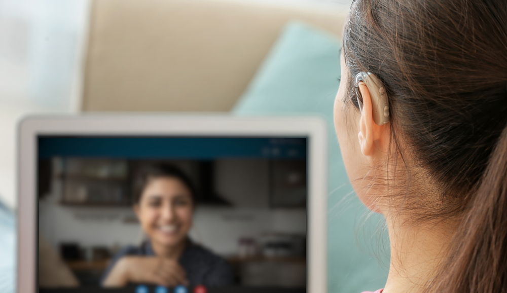 Woman with hearing aid talking to a recruiter on a video call